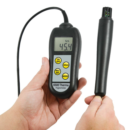 une personne tenant un Thermomètre à hygromètre 6500 Therma de Thermometre.fr et une sonde.