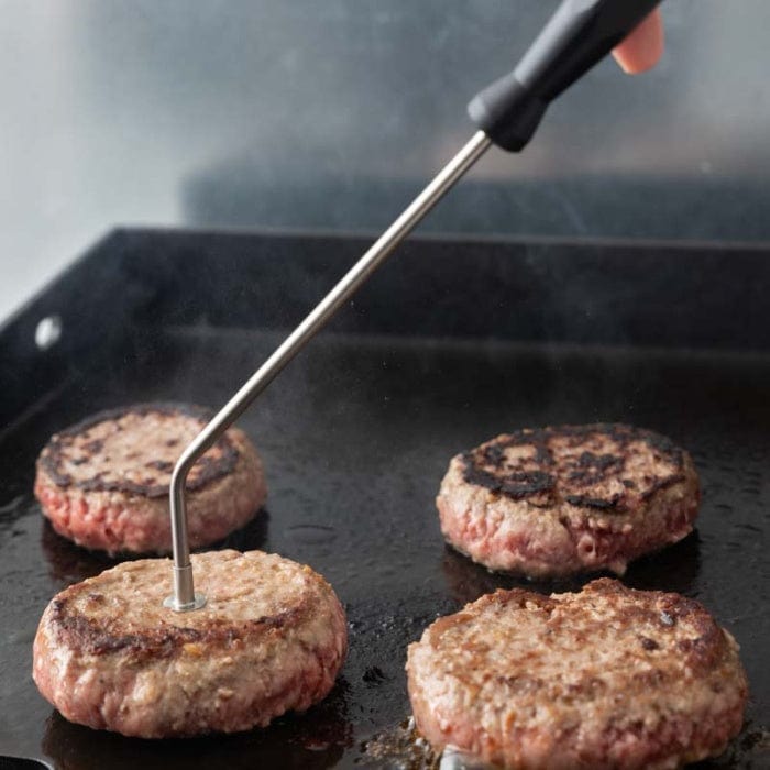 Un burger à la Sonde de température en cours de cuisson sur une poêle par Thermomètre.fr.
