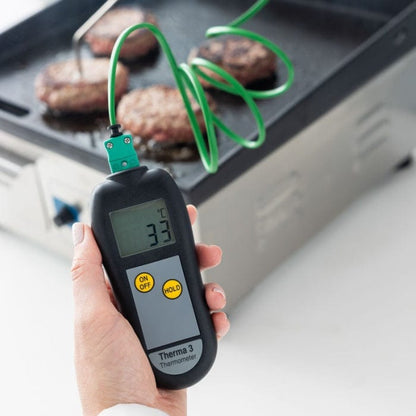 Une personne vérifie la température d’un grill avec une Sonde de température Thermomètre.fr.