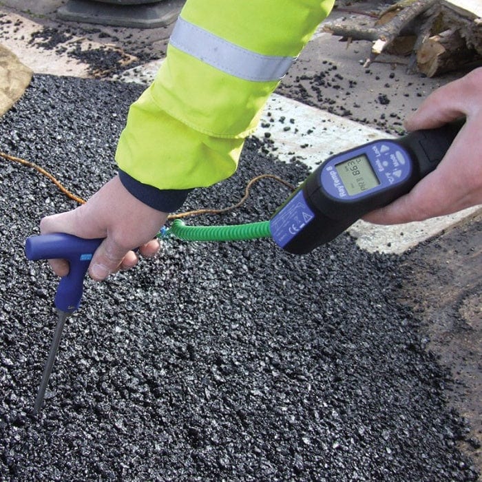 Une personne utilise un Kit thermomètre infrarouge - RayTemp 8 de Thermometre.fr pour mesurer la température d'une route.