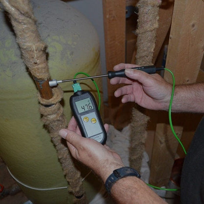 Un homme utilisant un thermomètre Thermometer.fr pour mesurer la température d'un chauffe-eau dans le cadre d'un Kit de thermomètre pour le contrôle de la légionellose.