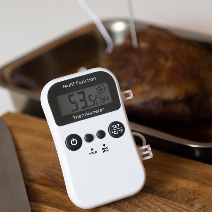 Thermomètre alimentaire numérique avec un Thermomètre multifonction - thermomètre numérique pour restauration, affichant 53,5°c, inséré dans un steak sur une planche à découper en bois.