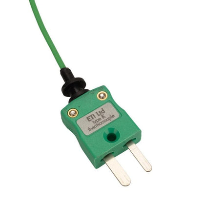 Une fiche électrique verte avec un cordon noir pour Sonde de température pour four de Thermomètre.fr, pour un réglage précis de la température.