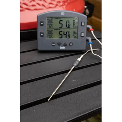 Une sonde de pénétration Thermometre.fr pour DOT ou ChefAlarm sur une table à côté d'un grill.