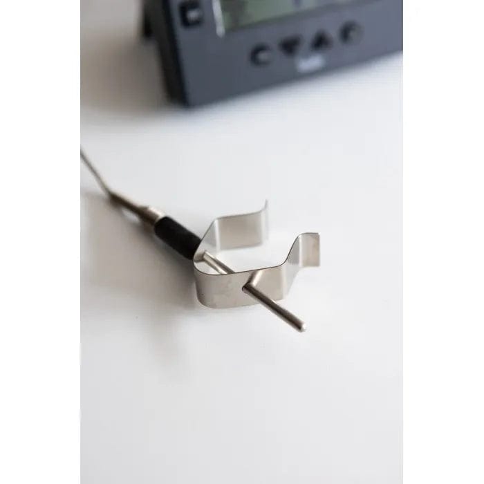 une Sonde et clip pour four DOT / ChefAlarm de Thermometre.fr sur une table à côté d'un thermomètre.