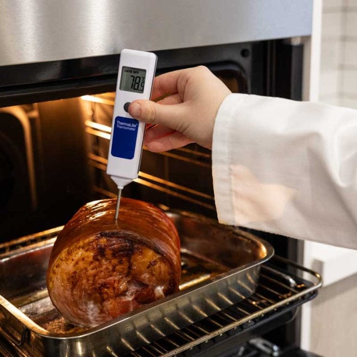 Un chef utilise un NOUVEAU Thermomètre à sonde alimentaire ThermaLite de Thermomètre.fr pour vérifier la température d'un rôti dans un four.