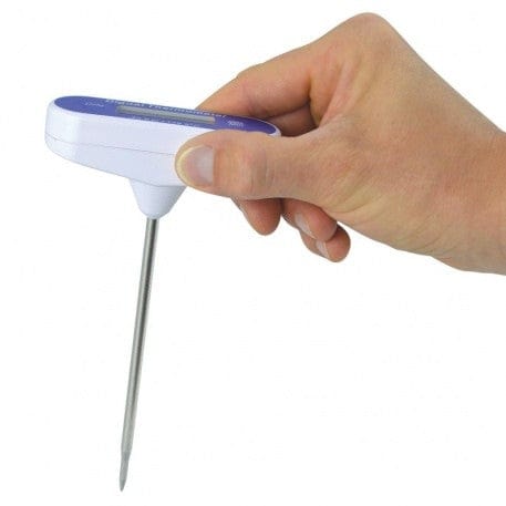 una persona in possesso di un termometro impermeabile - termometro tascabile a forma di T di Thermometer.fr su sfondo bianco.