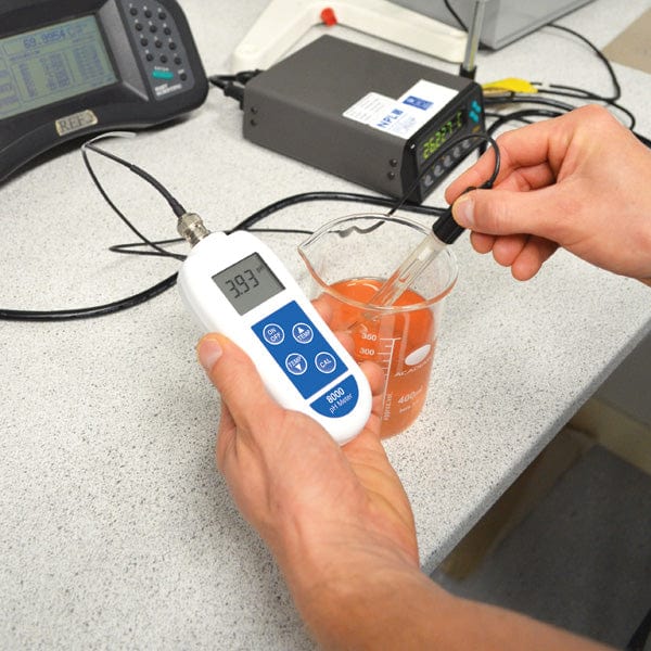 une personne utilisant un Thermomètre.fr PH-mètre 8000 avec électrode interchangeable pour mesurer un liquide.