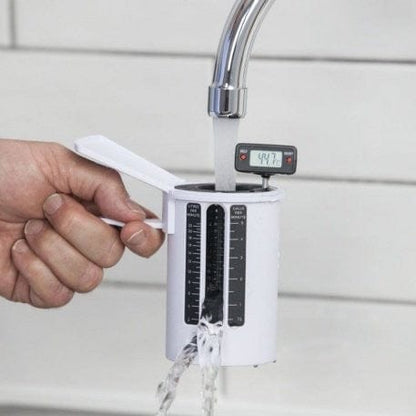 une personne tenant un Thermomètre numérique avec Flow Cup de Thermometre.fr devant un robinet.