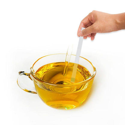 Une personne utilise les Bandelettes de test d'huile de friture de Thermometre.fr x 100, x 50, x 30 ou x20 dans un récipient rempli d'huile.